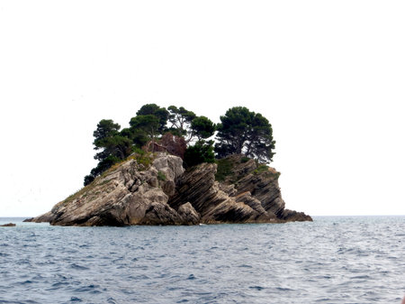 Katic Island Nature Park features a rocky shoreline surrounded by clear blue waters and vibrant greenery, making it a perfect destination for nature lovers in Montenegro.の写真素材