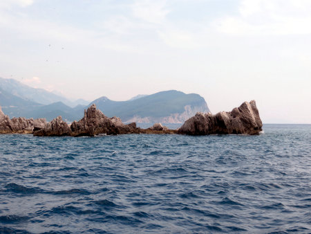 Waves gently lap against the rocky formations of Katic Nature Park near Sveta Nedjelja Island, showcasing Montenegros stunning coastal scenery and natural beauty.の写真素材