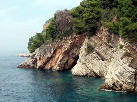 Exploring the stunning rocky coastline in Petrovac, Montenegro, this bay offers crystal-clear waters and breathtaking views of lush cliffs and serene surroundings.の写真素材