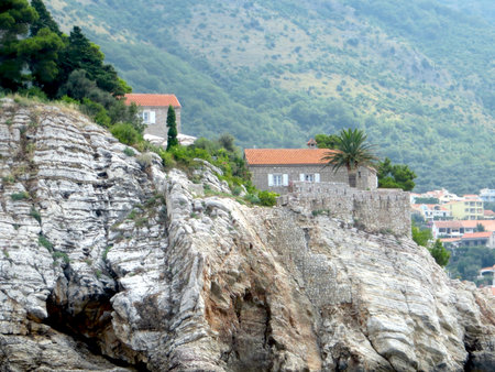 Visit the beautiful Sveti Stefan island resort in Montenegro, featuring rocky cliffs, traditional houses, and lush greenery. Perfect for travelers seeking tranquility and beauty.の写真素材