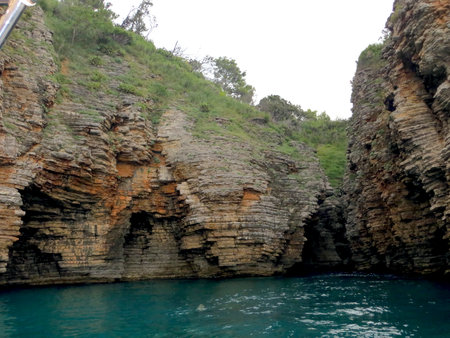 Spectacular rocky cliffs rise from the turquoise sea surrounding Sveti Nikola island, showcasing Montenegros stunning landscape and inviting exploration of natures artistry.の写真素材