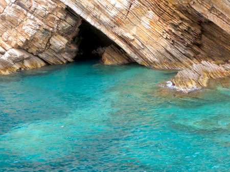 Enjoy the breathtaking clarity of turquoise waters in Petrovac bay, Montenegro, surrounded by dramatic rocky cliffs and serene coastal beauty.の写真素材