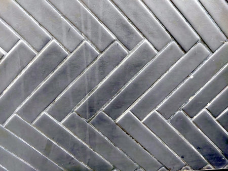 This black zigzag tile pattern showcases a glossy finish, making it suitable for walls or floors in...
