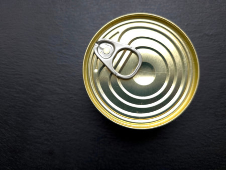 A tin can sits on a flat surface with a key attached. The can is ready to be opened for various uses...
