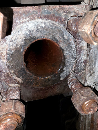 Metal pipes with visible deposits are examined closely. This observation takes place during a...