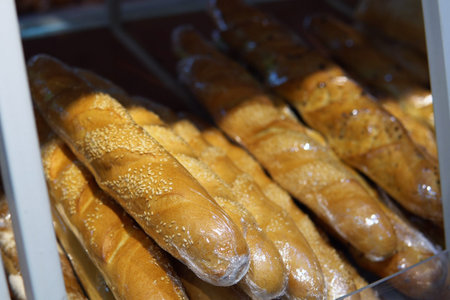 A variety of fresh baguettes on the shelf of the bakery department in the supermarket.