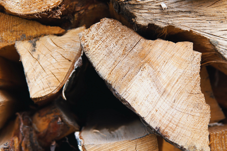 Stacked firewood prepared for the fireplace and stove in a large log woodpile in the yard, close up.の写真素材