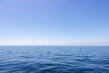 Seascape with sea horizon and almost clear deep blue skyの写真素材