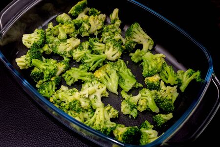 green broccoli n a glass plate on a black backgroundの写真素材