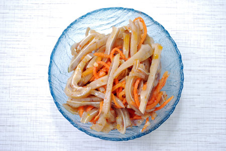 Salad from pork ears and carrots in Korean in a plate on a tableの写真素材