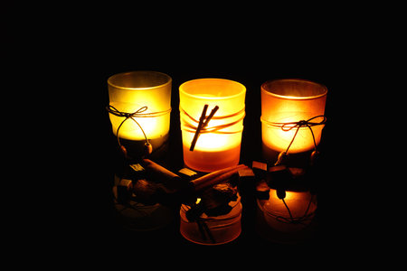 Three candles on black reflection surfaceの写真素材