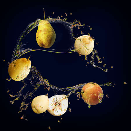 Juicy tasty pear with splashes of juice background for designersの写真素材
