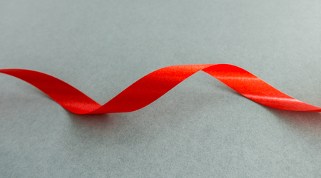 Shiny red ribbon with soft shadow on gray backgroundの写真素材