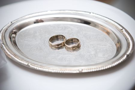 two wedding rings on the decorated plateの写真素材