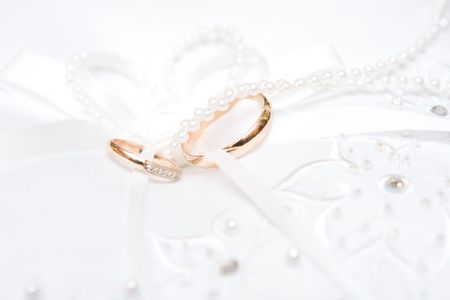 golden rings on the decorated white dress with tapes and beadsの写真素材