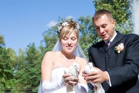 bride and groom with white pigeons in handsの写真素材