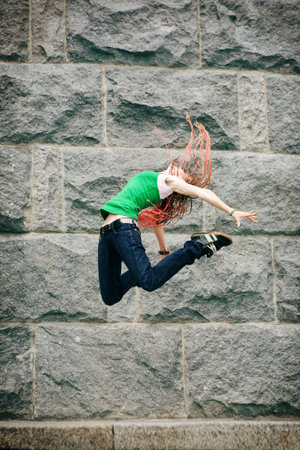 modern girl jumping near the wall