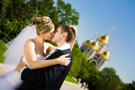 bride and groom kissing in the parkの写真素材