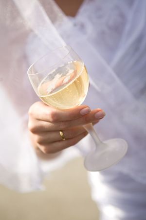 glass of champagne in a hand of a brideの写真素材