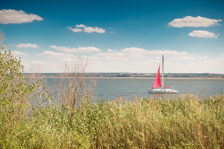 boat under the red sail in the seaの写真素材