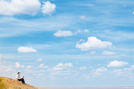 man with laptop and blue sky