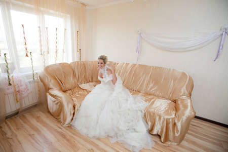 happy bride waiting for a groom on the sofaの写真素材