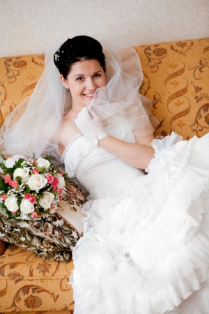 happy bride sit on the sofaの写真素材
