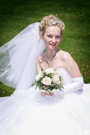 beautiful bride with rose bouquet outdoorsの写真素材