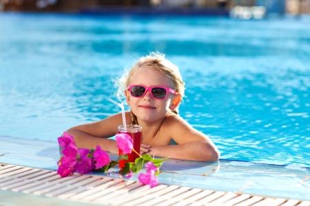 small girl drinking coctail in the poolの写真素材