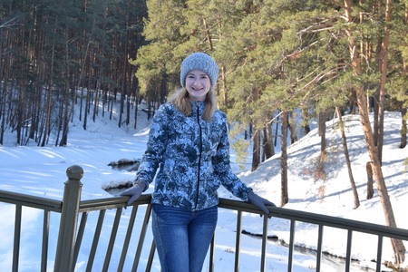 Sport girl in the forest standing on the bridge over the creek in early spring.の写真素材