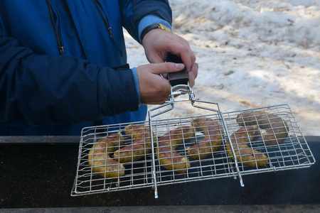 The man is cooking fried on the grill sausages.の写真素材