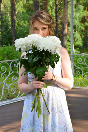 A happy girl in a long dress with flowers.の写真素材