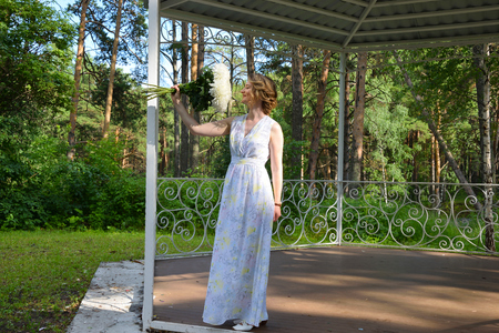A happy girl in a long dress with flowers.の写真素材