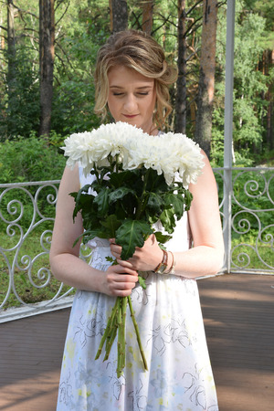 A happy girl in a long dress with flowers.の写真素材