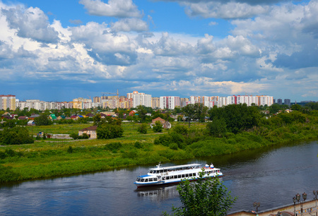 Construction of a new microdistrict in the Siberian city against the backdrop of the river and ship.の写真素材