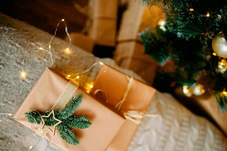 New Year's gift lies on the background of lights under the tree. New Year's and Christmas. Wrapped Giftsの写真素材