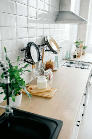 minimal white kitchen interior with plant on wooden countertops. Real photoの写真素材