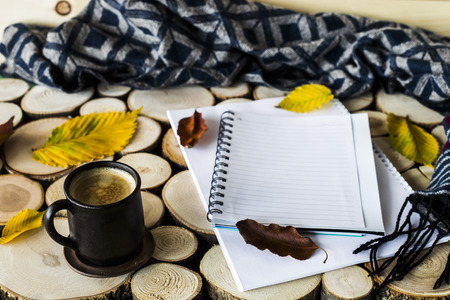 autumn workplace with a cup of coffee and a notebookの写真素材