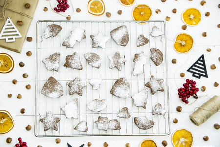 ginger biscuits on a grate on a grate on a white wooden table among the Christmas decorations. Top view. Flat layの写真素材