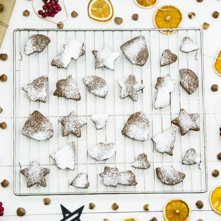 ginger biscuits on a grate on a grate on a white wooden table among the Christmas decorations. Top view. Flat layの写真素材