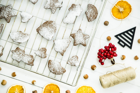 ginger biscuits on a grate on a grate on a white wooden table among the Christmas decorations. Top view. Flat layの写真素材