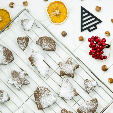ginger biscuits on a grate on a grate on a white wooden table among the Christmas decorations. Top view. Flat layの写真素材