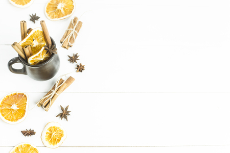 ingredients of spices and oranges for mulled wine inside and around the clay cup. background. copyspaceの写真素材