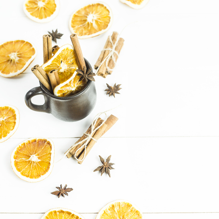 ingredients of spices and oranges for mulled wine inside and around the clay cup. background. copyspaceの写真素材