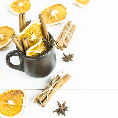 ingredients of spices and oranges for mulled wine inside and around the clay cup. background. copyspaceの写真素材
