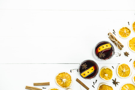 Two cups with hot mulled wine among spices and dried oranges. background. Copyspace. Top viewの写真素材