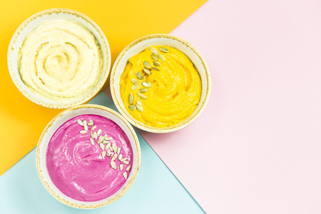 bright appetizers in the form of vegetable sauces and hummus of chickpeas on a combination multicolored background. Copyspaceの写真素材