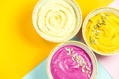 bright appetizers in the form of vegetable sauces and hummus of chickpeas on a combination multicolored backgroundの写真素材