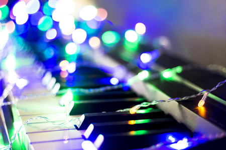 Christmas garland with lights on an electronic piano - decoration for the celebration of Christmas and New Yearの写真素材