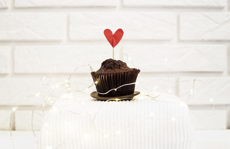 Chocolate muffin with a red heart. Valentine's Day concept. Sweet gift to the belovedの写真素材